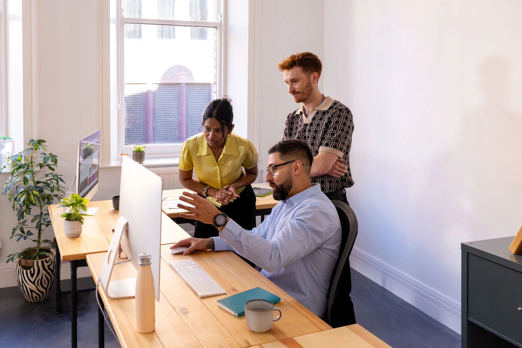 Team reviewing website design on a computer screen